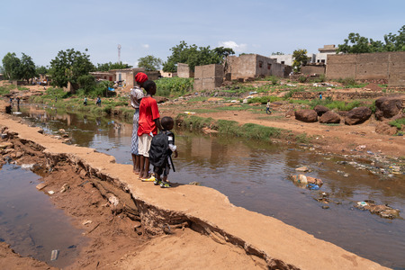 Group of African Village children looking desolately at the road washed away by the flood after heavy rainstorms, concept of global warming and climate.